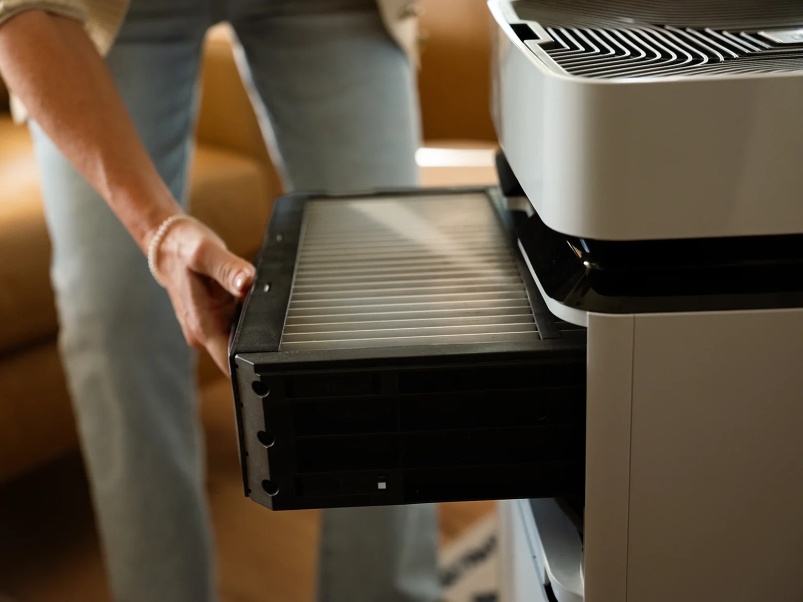 Person inserting a washable filter into an Airdog purifier in a living room